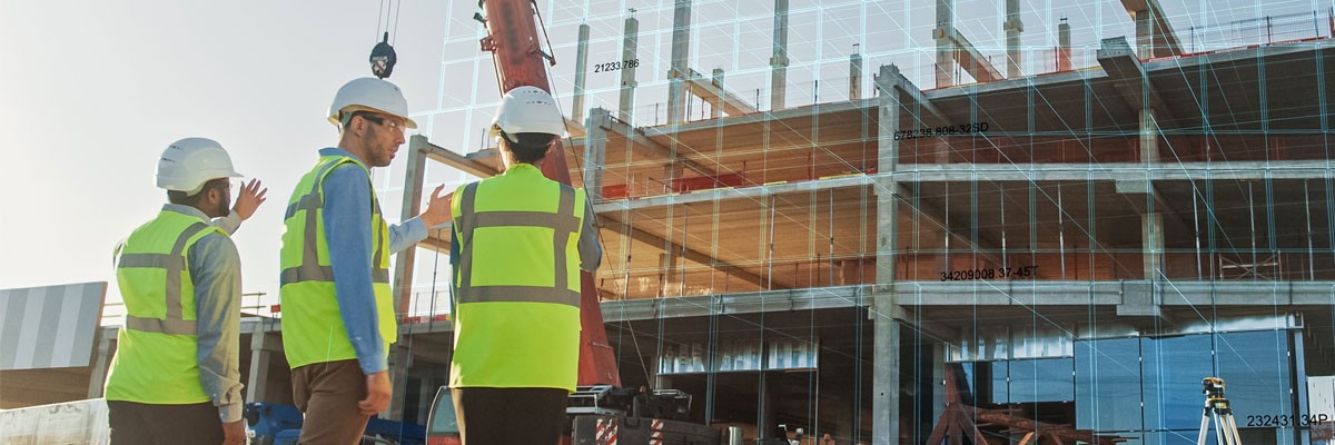 Group of engineers in hard hats overseeing construction onsite 