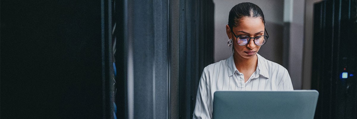 Business professional with laptop computer in data center