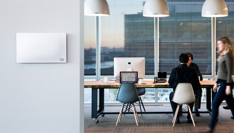 Business professionals working in modern office space using Cisco products and solutions
