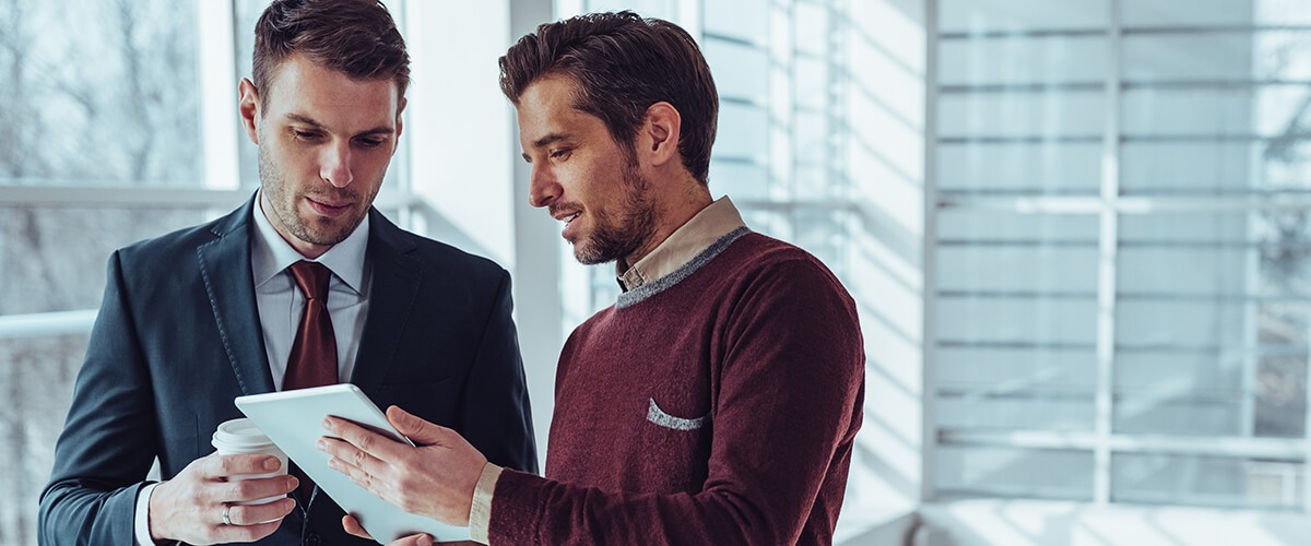 Two businessmen looking at computer tablet device