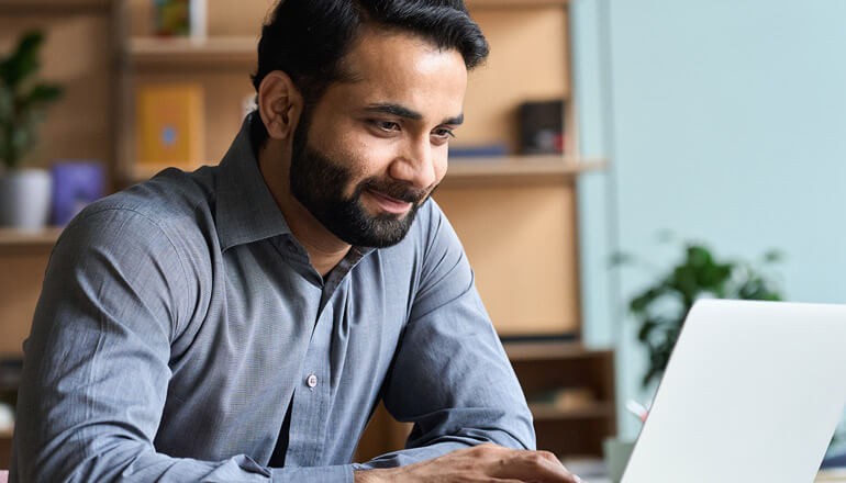 Man using laptop for work at home. Windows 11, Device deployment, device manageability, deployment and manageability 