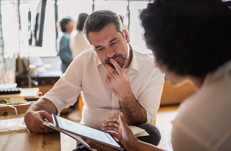 Identify your power gaps with a free assessment. Two business professionals reviewing technical data on a tablet at work.