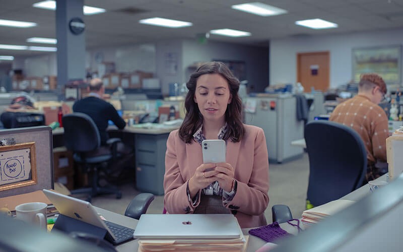 Apple at Work flexible cost Woman using Apple iPhone and Mac in office