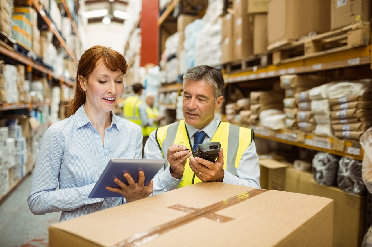 For manufacturing woman working with an employee and using an apple product