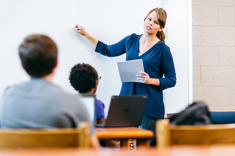 Inspire students with personal mobile devices from Dell Teacher at whiteboard leading a science class