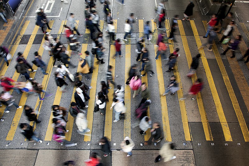 Blurred people walking fast on busy city street