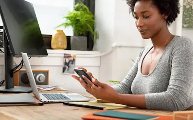 Built with your business in mind Woman using her phone in front of laptop