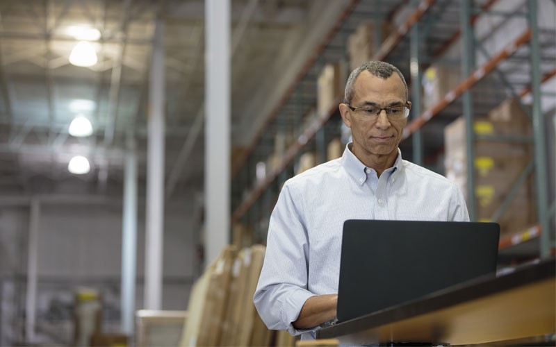 IT operations for business management and solutions Business man working on laptop in warehouse