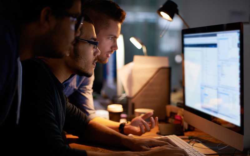 IBM security software Male coworkers collaborating at desk
