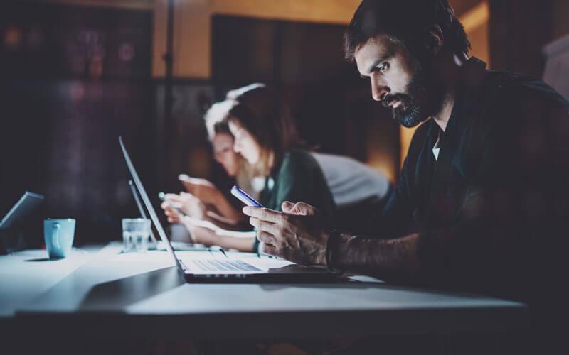 IBM endpoint management solutions Man using laptop and mobile phone