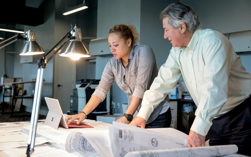 Federal government IT ecosystem Two coworkers collaborating using Microsoft device