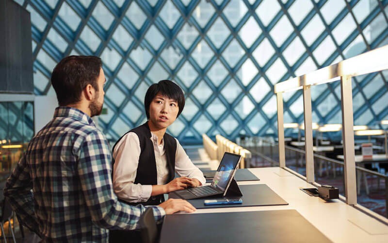 Dynamics 365 for federal government Woman and man collaborating with Microsoft Surface