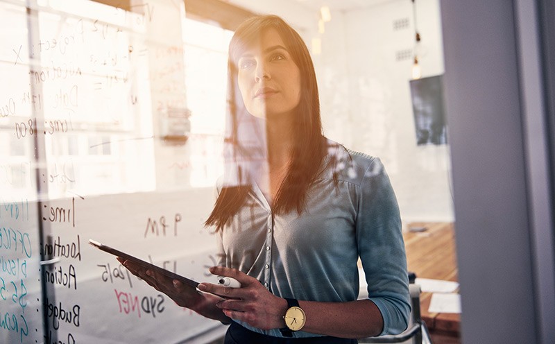 Analyze your data directly within the SQL Server Woman holding tablet while thinking at white board
