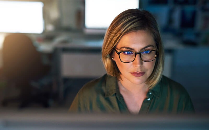 Mitel Product Security Incident Response Team Woman looking at desktop monitor