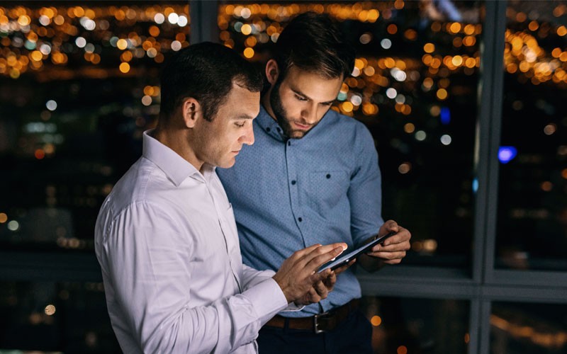 two-business-men-collaborating-over-tablet two-business-men-collaborating-over-tablet