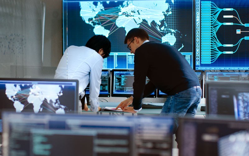 Ipswitch WhatsUp Gold and MOVEit control your data Two men working on computer in security operations room