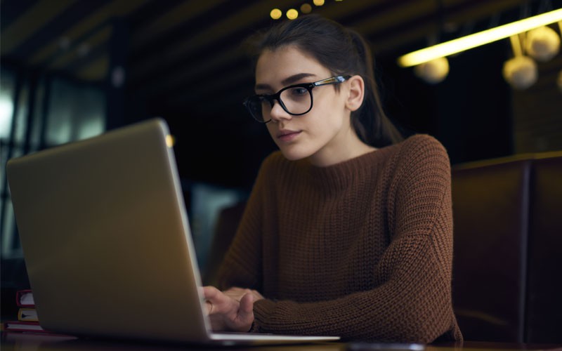 Proofpoint Phishing Simulations and security awareness training Woman working on laptop remote