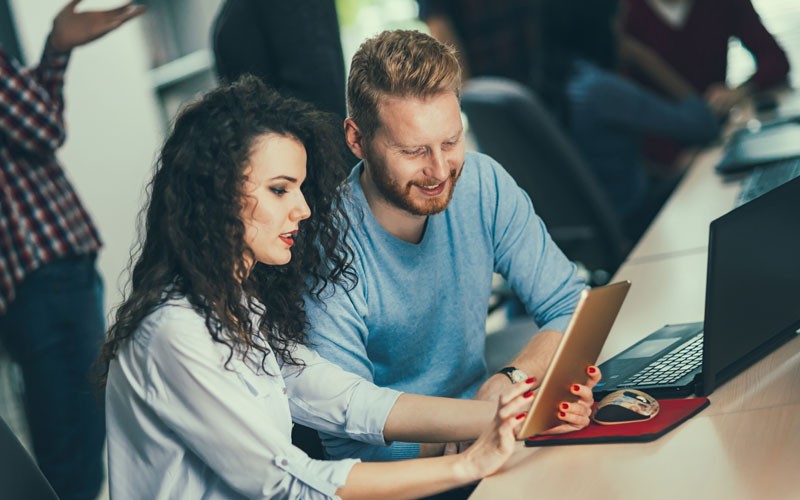 Trend Micro Smart Protection Complete Two teammates collaborating at desk