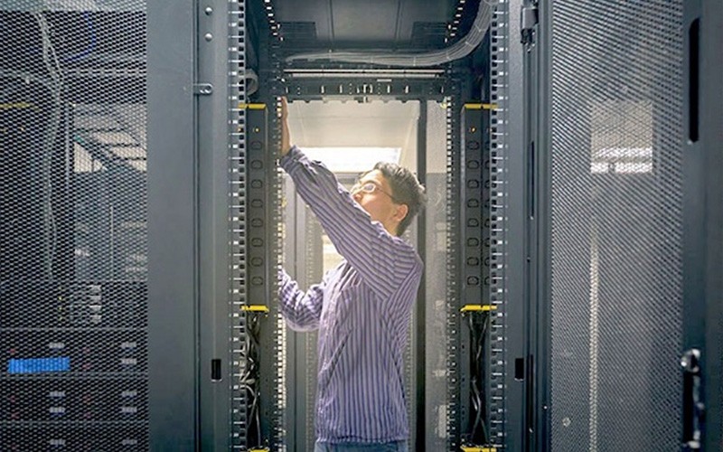 Vertiv integrated systems combine thermal, power and IT management in a single plug-and-play system for fast deployment. Employee on a data center