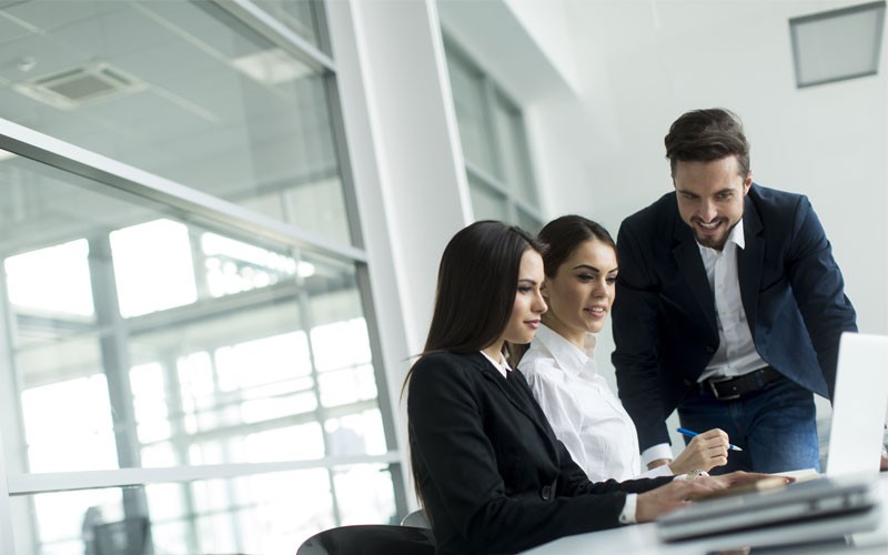 Federal government IT technology Three business employees looking over multiple technology devices