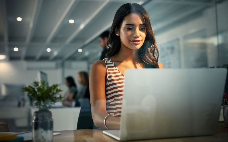 A unified hybrid cloud platform connects, manages, and secures apps across multiple clouds Woman typing on laptop