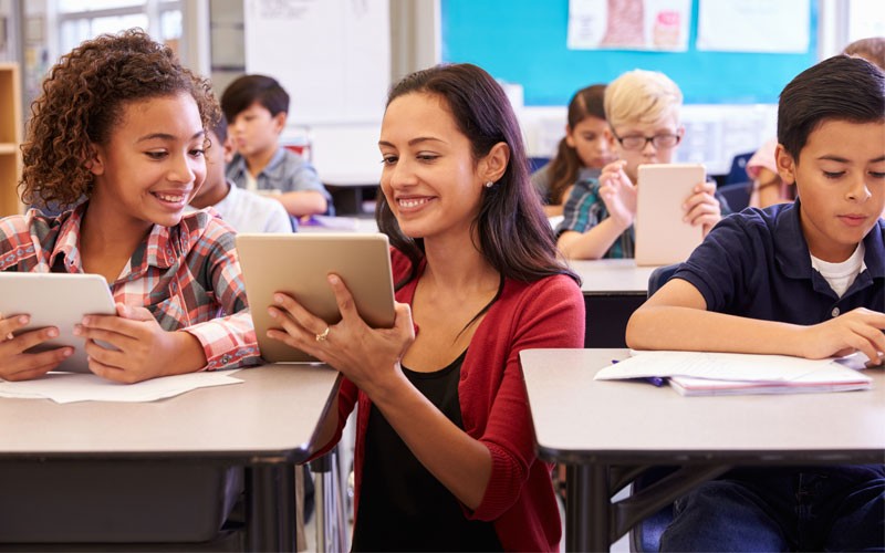 VMware solutions for education Teacher using tablet device with students