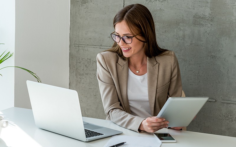 Modernize your applications and infrastructure to deliver better software continuously. Woman using her tablet and laptop