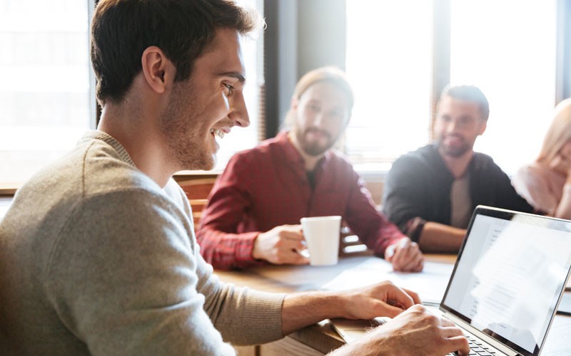 Enable a feature-rich user experience for end users across devices, locations, media and network connections Man using laptop smiling