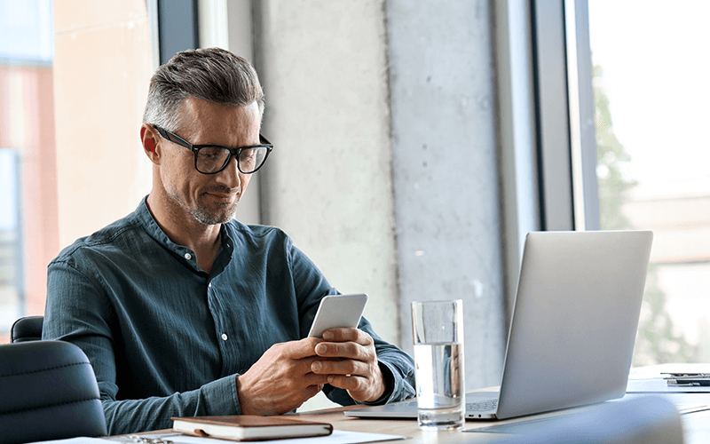 Bringing everything together Man with glasses on phone and computer