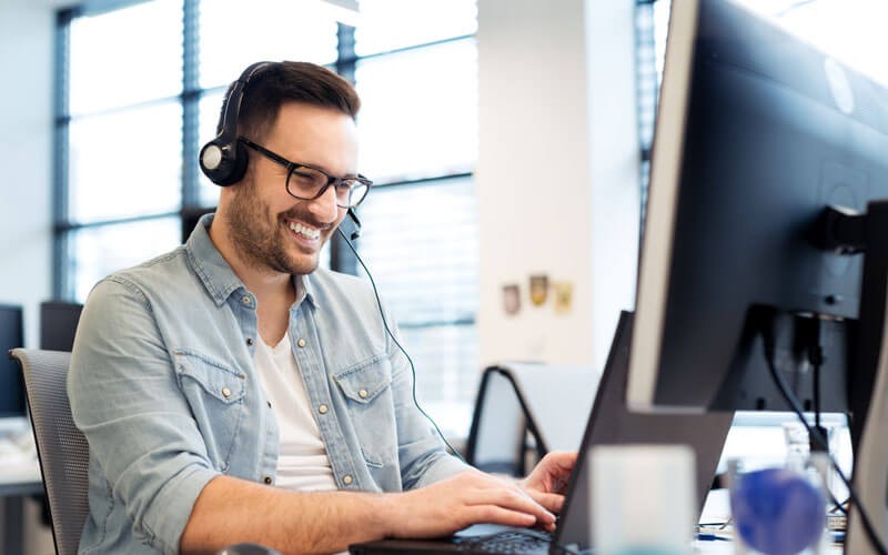 Vonage Business Cloud provides one reliable solution Man smiling on phone and computer