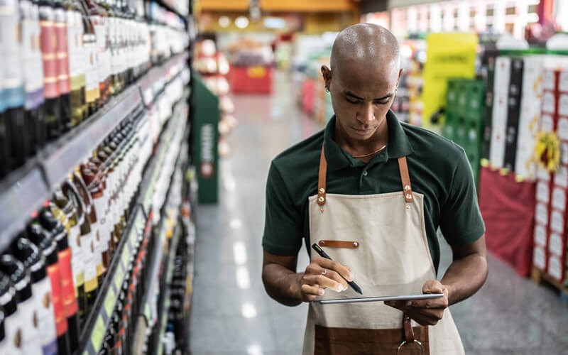 Increase automation and place workloads where business happens Grocery Clerk on digital tablet in modern supermarket