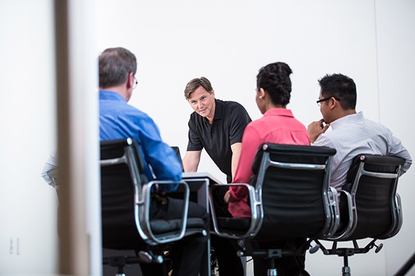 Together we can help your business do more Business man leads meeting with other professionals