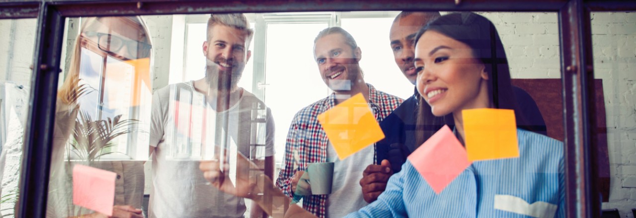 Business people meeting at office and use post it notes to share idea. Brainstorming concept. Sticky note on glass wall