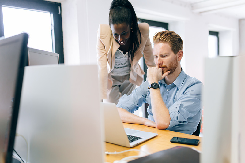 Two business professionals looking over technology devices