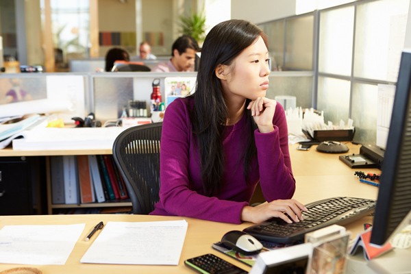 Asian woman in office working on a computer