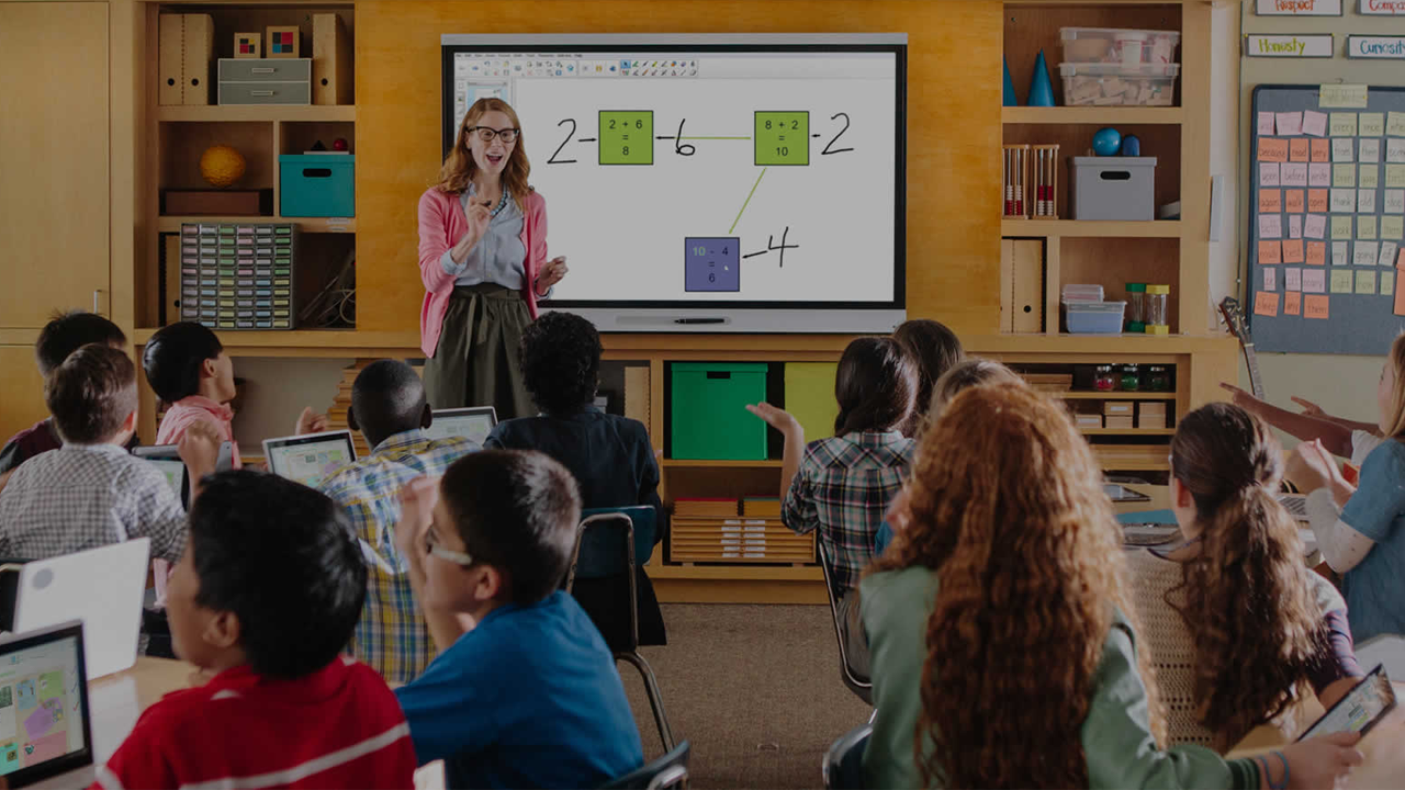 Female teacher in front of digital chalkboard in front of class