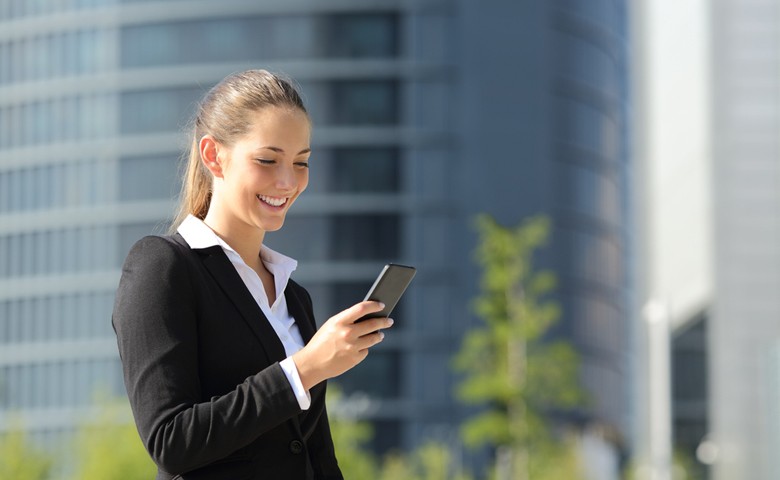 Federal employee in suit outside looking at cell phone.