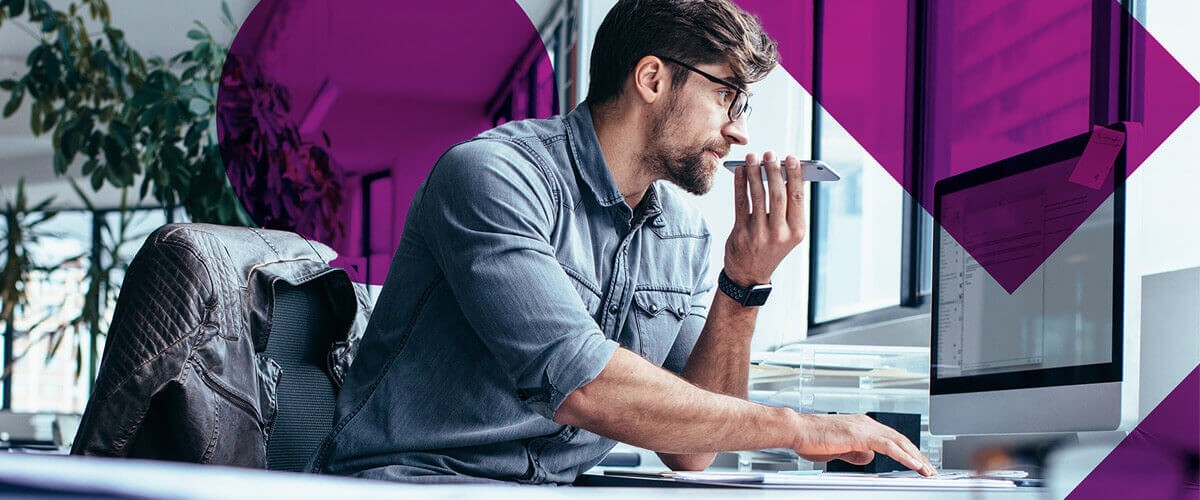 Business professional talking on phone while using work computer