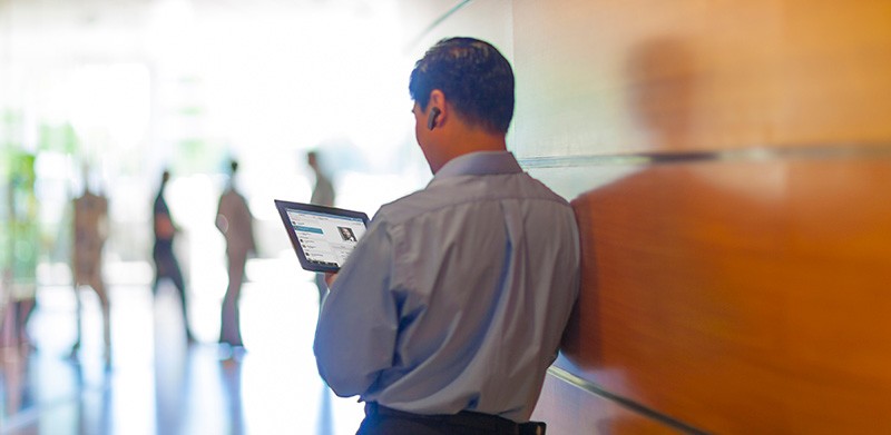 Use your mobile device to collaborate Business executive videoconferencing in with team from tablet device