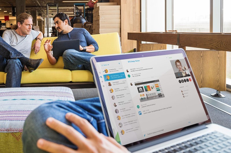 Modernize your communications Man sitting with table on crossed legs.