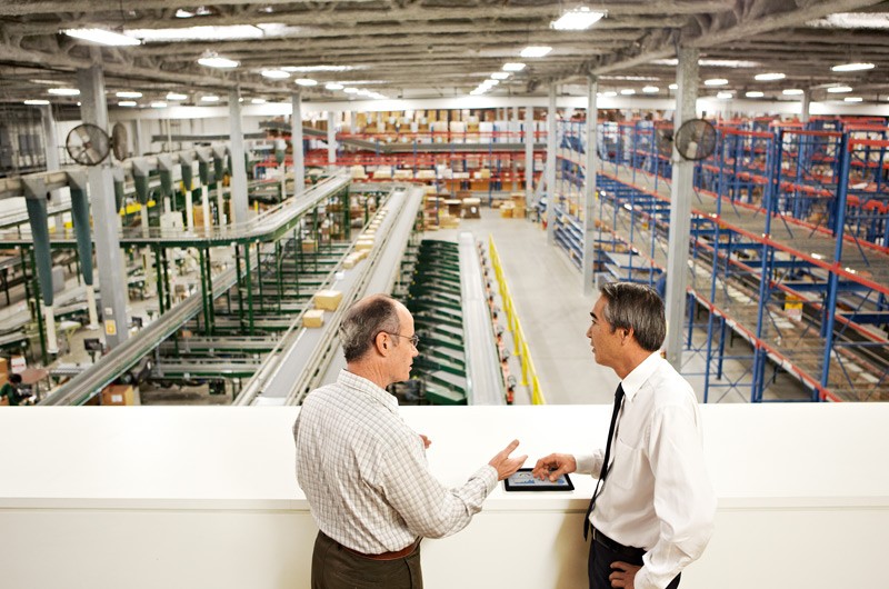 Data center Two men in industrial warehouse talking.