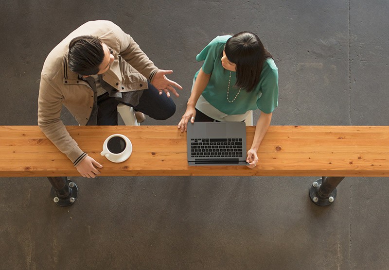Professionnel(le)s partageant des idées à l’aide d’ordinateurs portables