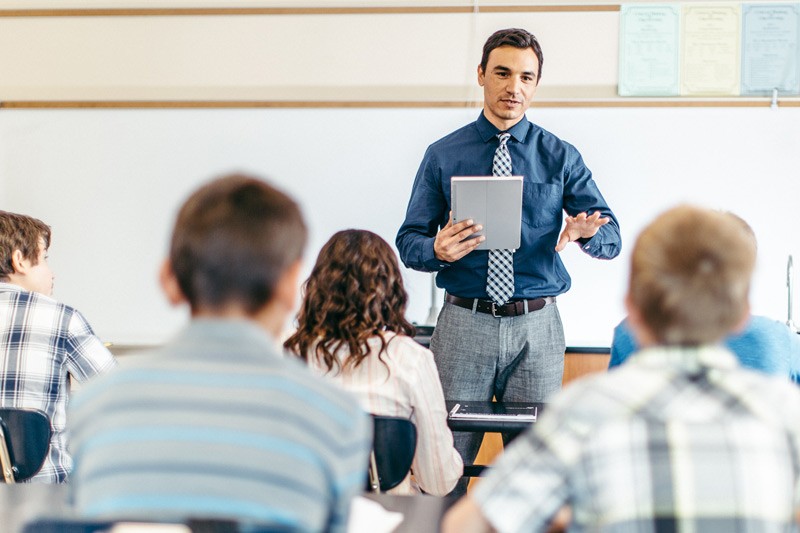 100% centralized cloud management for security, networking, & application control Teacher with tablet leading a science class
