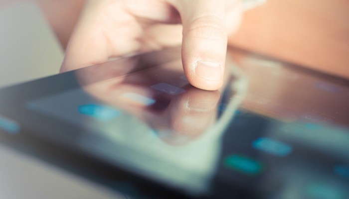 Self-enroll directly on their mobile devices by installing a downloadable app Close up of hands using a smart phone device
