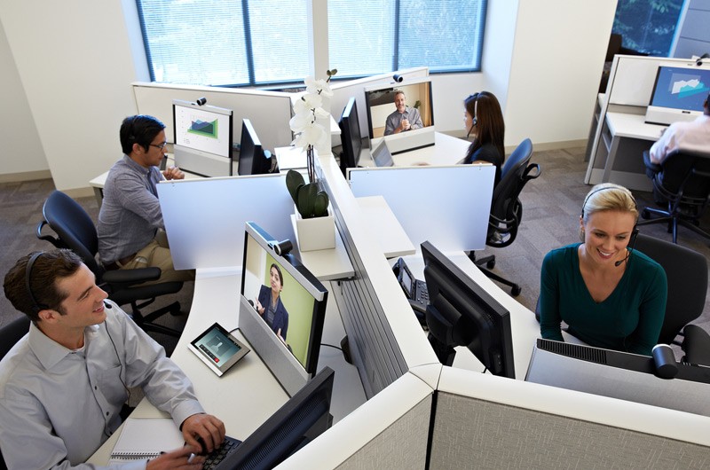 Cisco transactional licensing program Office cubicles with workers working on their computers.