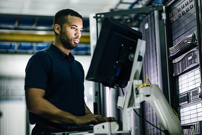 Defend and protect with advanced security. IT professional working on laptop it data center.
