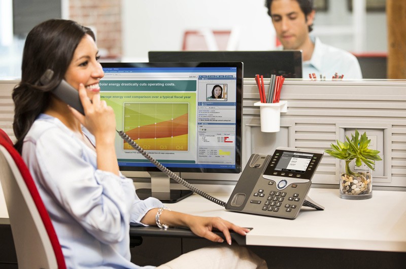 Software Asset Managemnet SAM Woman in white coat at her desk on the phone.