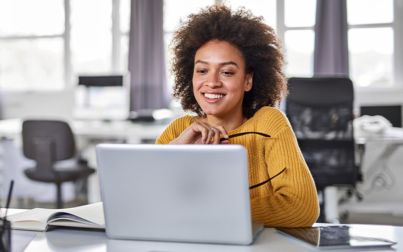 Une collaboration alimentée par l’IA woman smiling on laptop