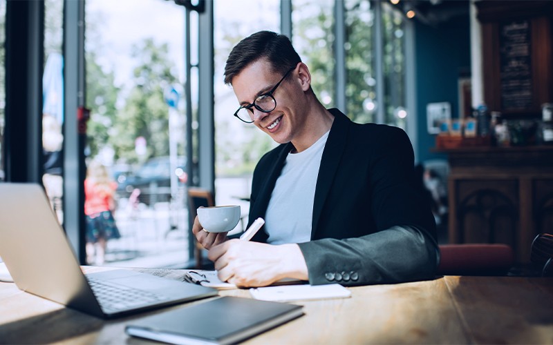 Ressources HP additionnelles man taking notes while drinking coffee