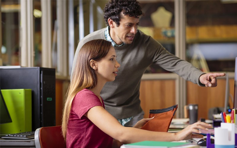 Employees collaborating in front of desktop